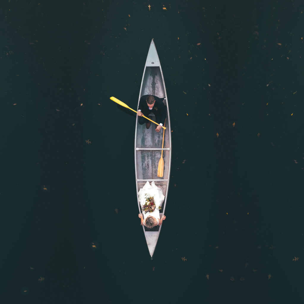 Overhead shot of couple out in the water riding a canoe 