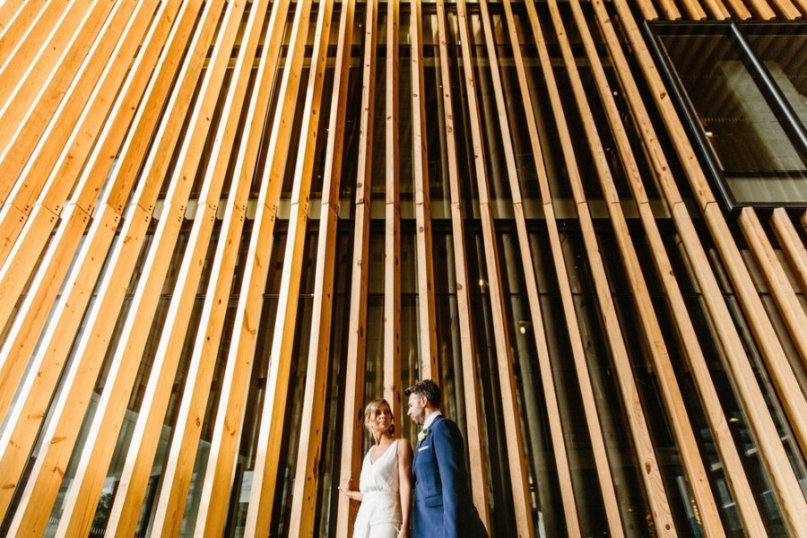 bride and groom walking in front of building