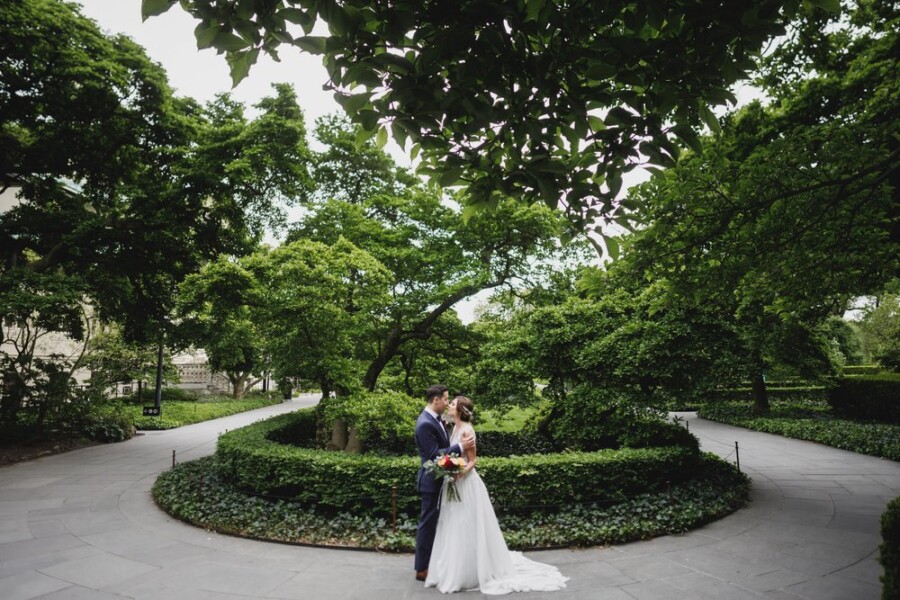 Bride and Groom embracing in front of trees