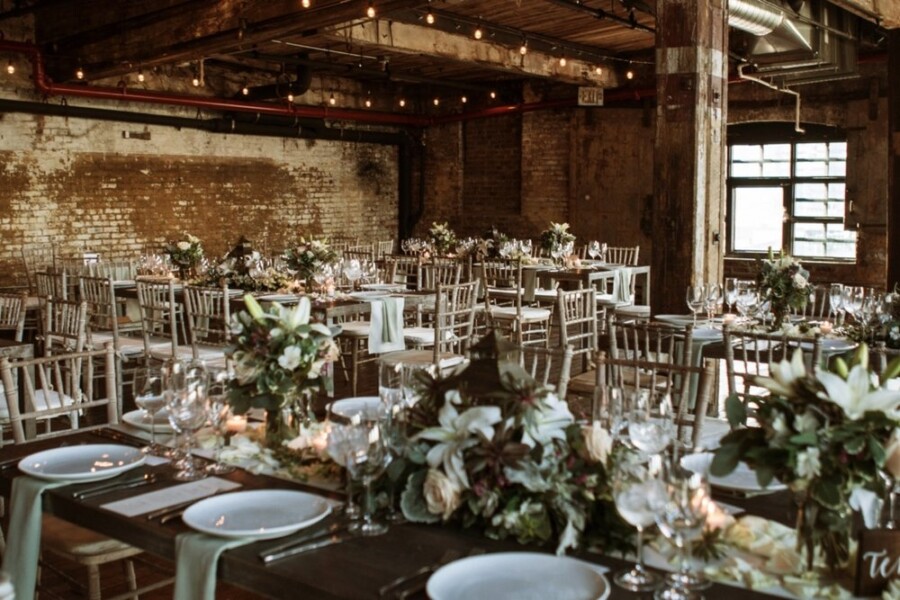 Rustic wedding reception venue with wooden tables decorated with flowers