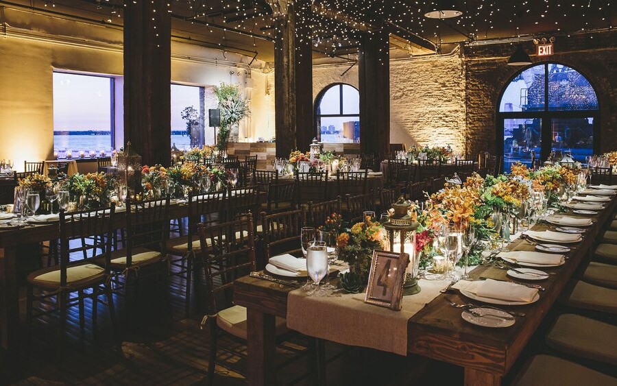 Rustic wedding reception venue with wooden tables decorated with flowers and tableware