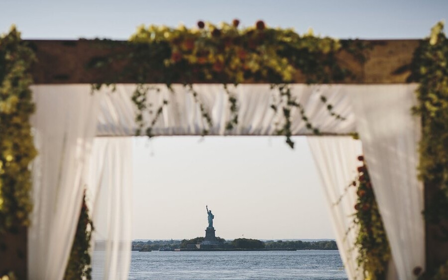 Framed shot of the Statue of Liberty under wedding arch