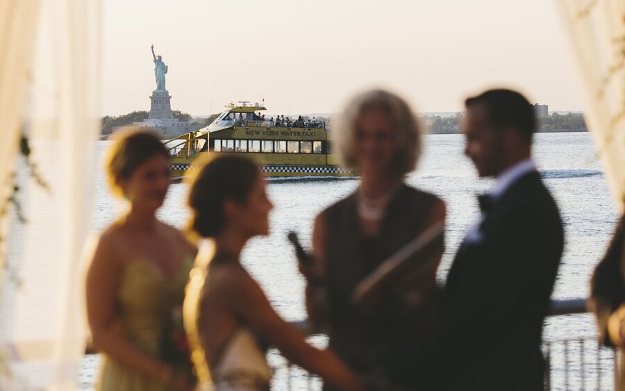 Couple getting married with Statue of Liberty in background